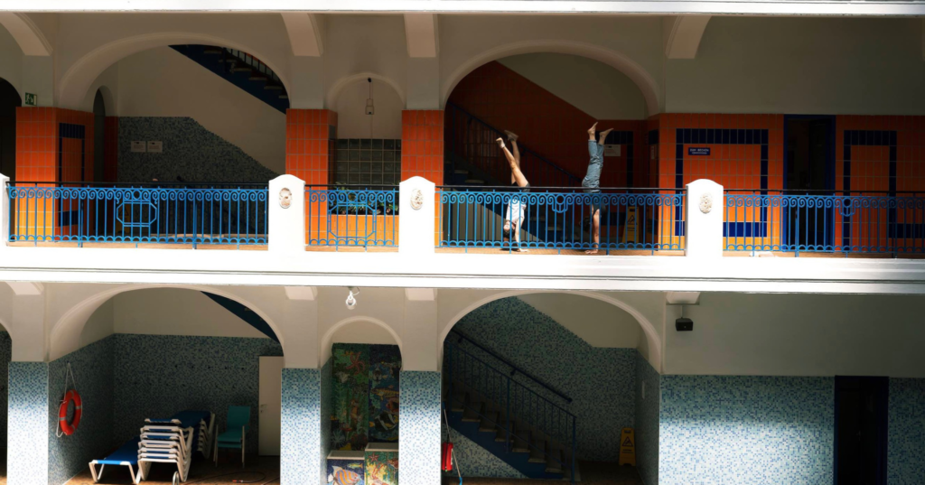 Photographie de la compagnie KUMQUAT réalisant des acrobatie sur le balcon d'un hôtel.